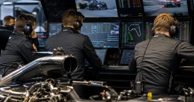 Ingénieurs de Formule 1 analysant les données moteur 2026 dans un garage high-tech pendant la saison F1 2026, illustration du système ADUO mis en place par la FIA.